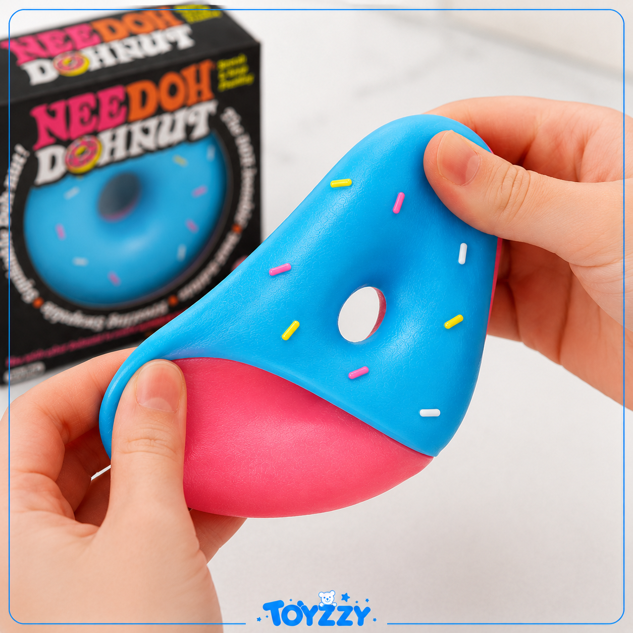 Blue and pink NeeDoh Dohnut being stretched by hand